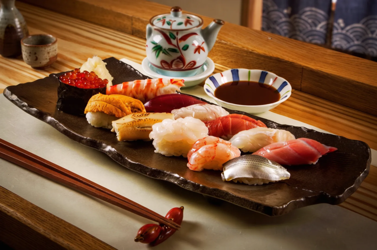 Luxury sushi platter featuring uni, ikura, tuna, and shrimp nigiri served on a ceramic plate at a high‑end Japanese restaurant in Singapore.
