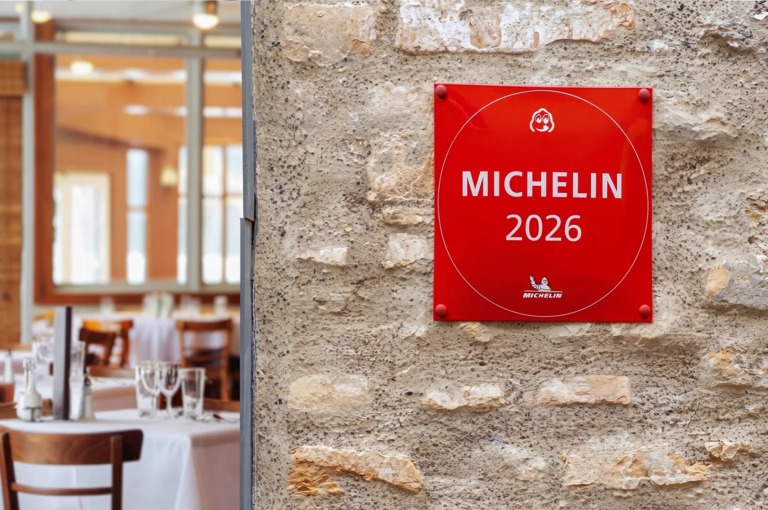 Red Michelin 2026 plaque mounted on a rustic stone wall outside a fine‑dining restaurant, symbolizing prestigious culinary recognition.