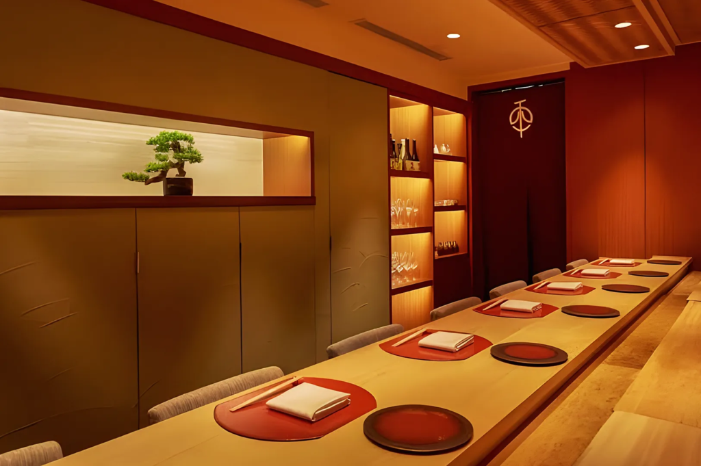 Minimalist Japanese fine‑dining interior with bonsai décor, warm lighting, and omakase counter seating in Singapore.