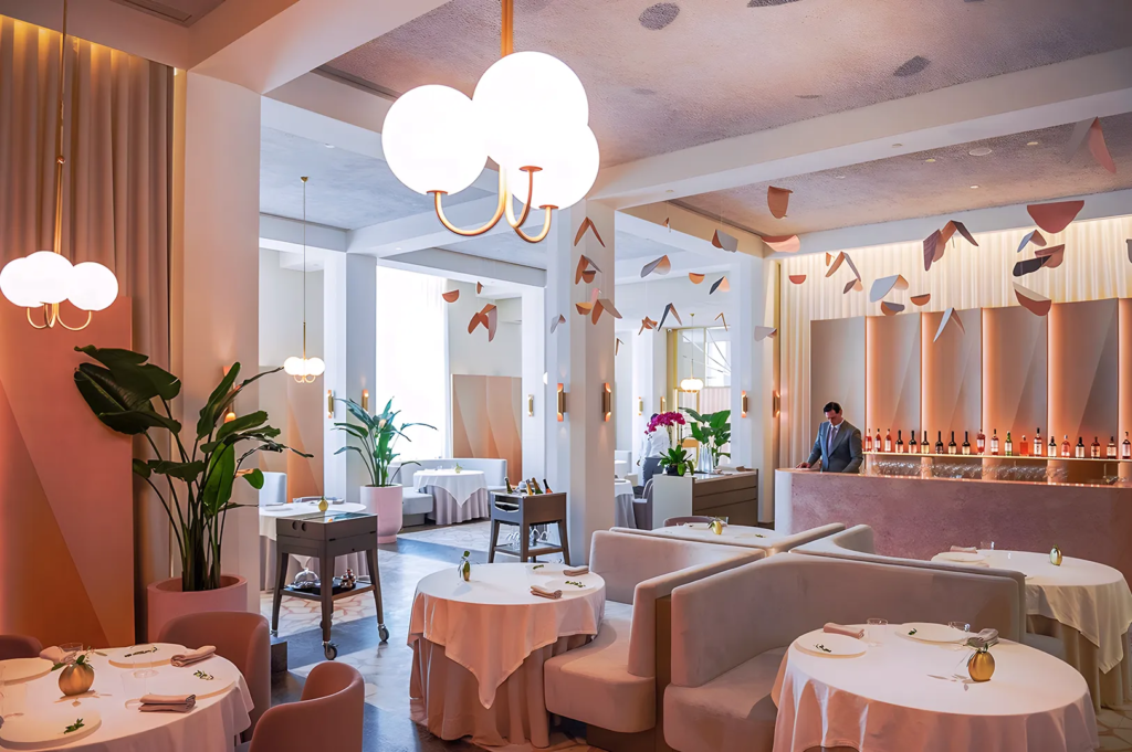 Luxurious dining room of Odette restaurant with pastel tones, sculptural ceiling art, and marble bar — Michelin‑starred French fine dining in Singapore.
