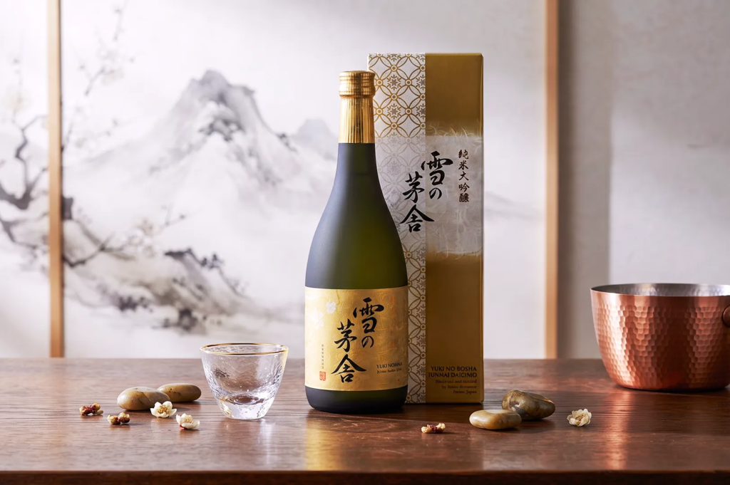 Gekkeikan Nigori sake bottle with frosted green glass and two cups of cloudy sake surrounded by pink cherry blossoms — traditional Japanese drink served in spring.