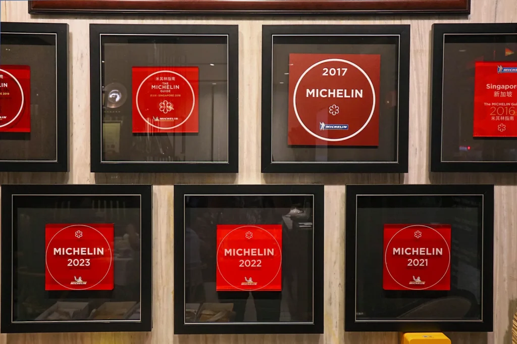 Collection of framed Michelin Guide plaques from 2016 to 2023 showcasing consistent culinary excellence and star recognition.