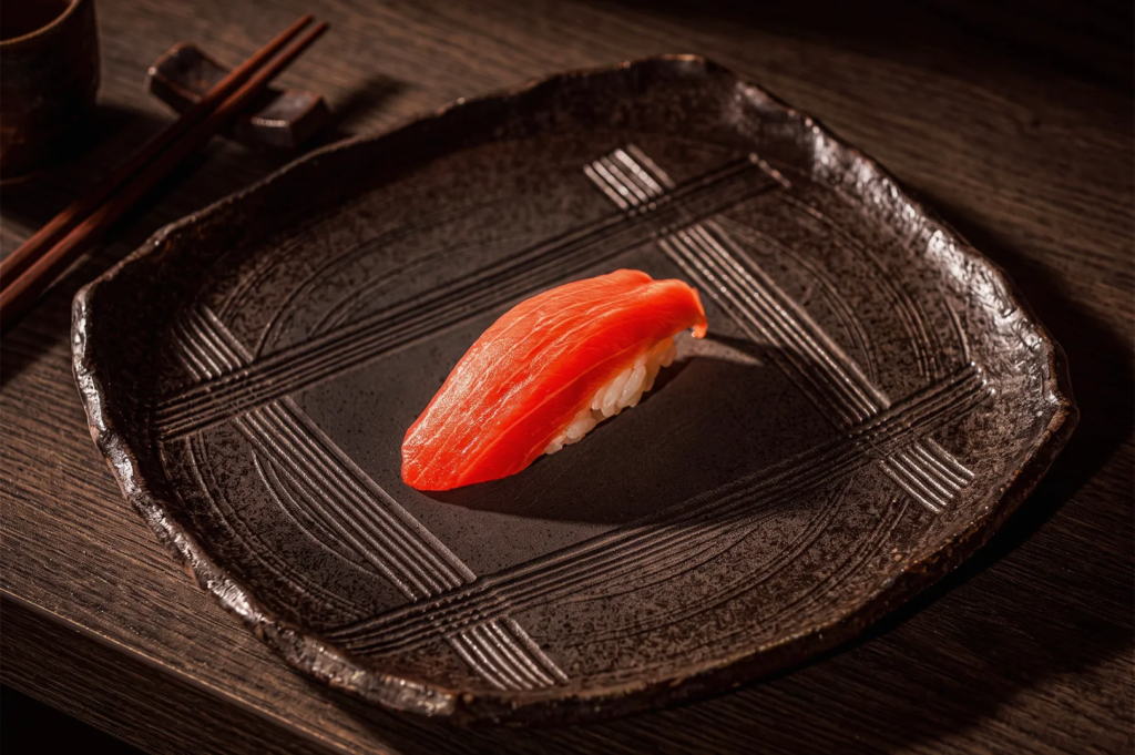 Close‑up of fresh tuna nigiri sushi served on a handcrafted ceramic plate at Shinji Singapore, showcasing premium Japanese cuisine.